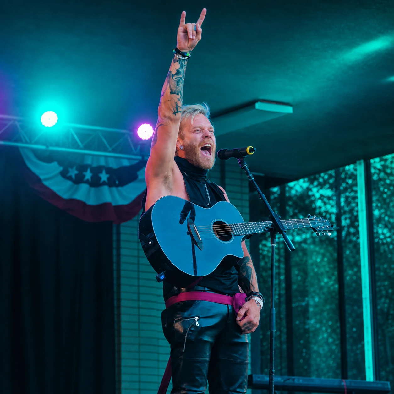Seth Bonnell performing live with a blue acoustic guitar